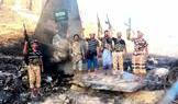 Houthi fighters stand in front of what they say is a downed Saudi jet, at a location given as Yemen