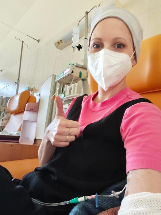 Adéla je aktivní maminka tří malých dětí, jejíž život se zčistajasna změnil během dovolené. Místo běžných rodinných radostí čelila náročné léčbě zahrnující chemoterapii, monoklonální protilátky a imunoterapii. Léčbu úspěšně zvládla i díky podpoře rodiny, praktickému přístupu a humoru.