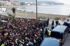 Police escort migrants from Benitez Beach to be relocated to the camp set up at the port of Ceuta