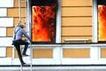 A combination picture shows a man climbing out of a window to escape from burning building, in Kyiv