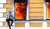 A combination picture shows a man climbing out of a window to escape from burning building, in Kyiv