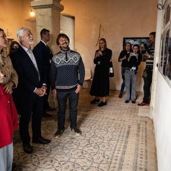 Prezident Petr Pavel si prohlíží postu prací na výpravní budově. 
