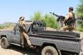 Government soldiers ride military pick-up vehicle on road leading to frontline in Taiz