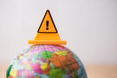 Close,Up,Yellow,Triangle,Emergency,Sign,On,Earth,Globe,With